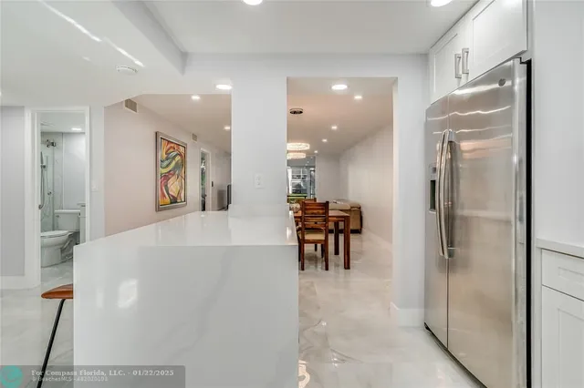 a view of a kitchen with furniture and a refrigerator