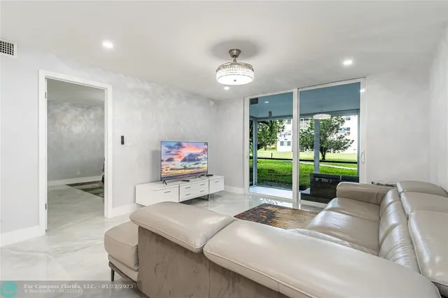 a living room with furniture a window and a flat screen tv