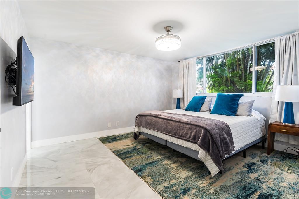 9523 South Hollybrook Lake Drive, Unit 102 Pembroke Pines, FL 33025 - Photo 18 of 63 a bedroom with a bed and a flat tv screen on dresser