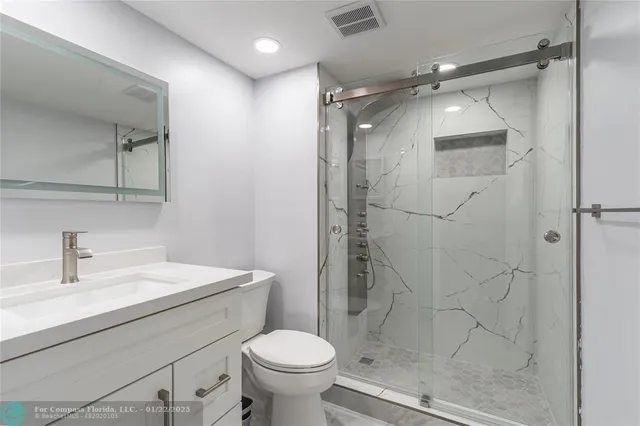 a bathroom with a shower toilet and sink