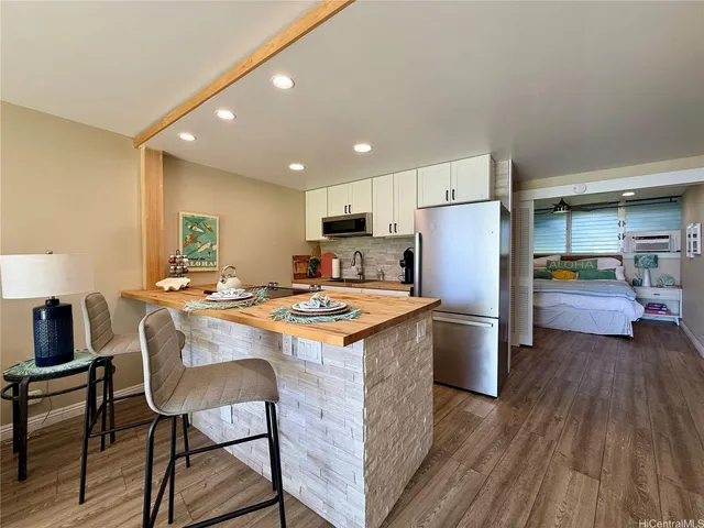 a kitchen with refrigerator a table and chairs
