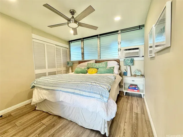 a bedroom with a bed and a large window with wooden floor