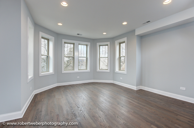 2329 West Barry Avenue, Unit 2 Chicago, IL 60618 - Photo 4 of 10 a view of an empty room with wooden floor and a window