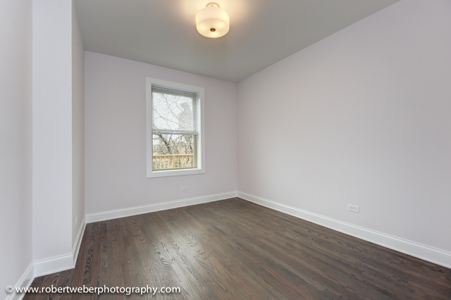 2329 West Barry Avenue, Unit 2 Chicago, IL 60618 - Photo 5 of 10 an empty room with wooden floor and windows