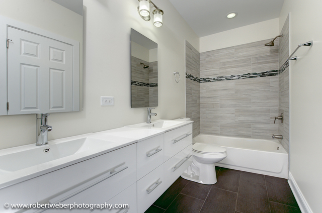 2329 West Barry Avenue, Unit 2 Chicago, IL 60618 - Photo 7 of 10 a bathroom with a double vanity sink toilet and shower