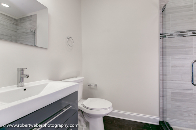 2329 West Barry Avenue, Unit 2 Chicago, IL 60618 - Photo 8 of 10 a bathroom with a sink a toilet and shower