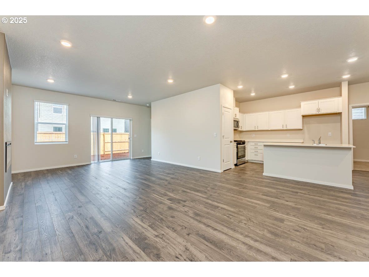 2963 U Street Springfield, OR 97477 - Photo 16 of 26 a view of a kitchen and an empty room with wooden floor