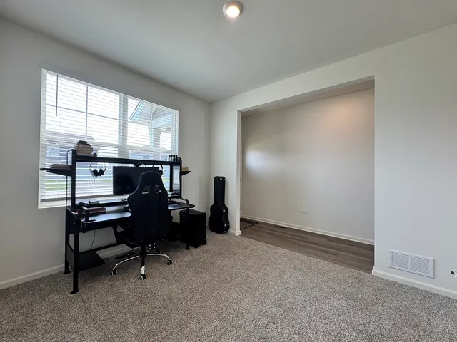 a view of a workspace with furniture and a window