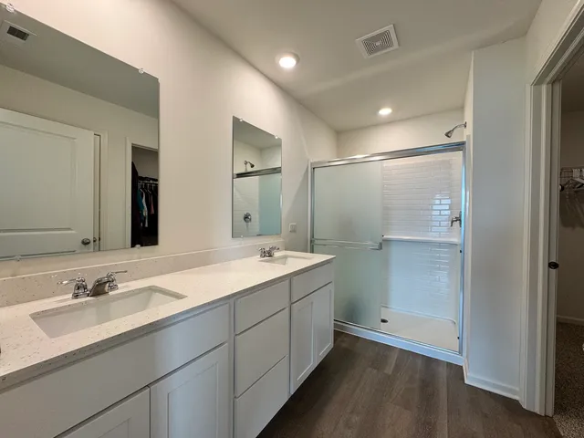 a bathroom with a double vanity sink mirror and shower