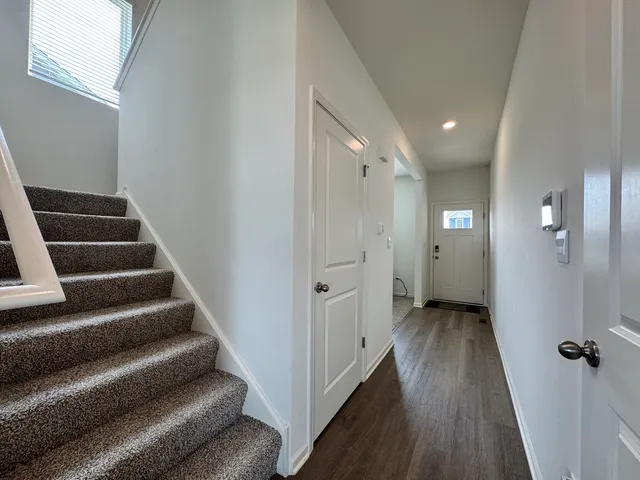 a view of a hallway with wooden floor and staircase