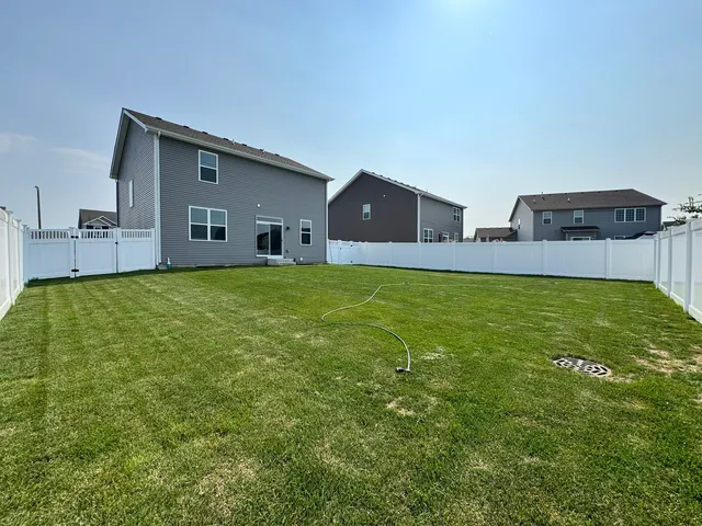 a view of a house with a yard and a garage