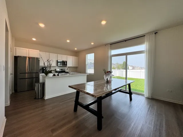 a kitchen with stainless steel appliances granite countertop a refrigerator microwave and wooden floor
