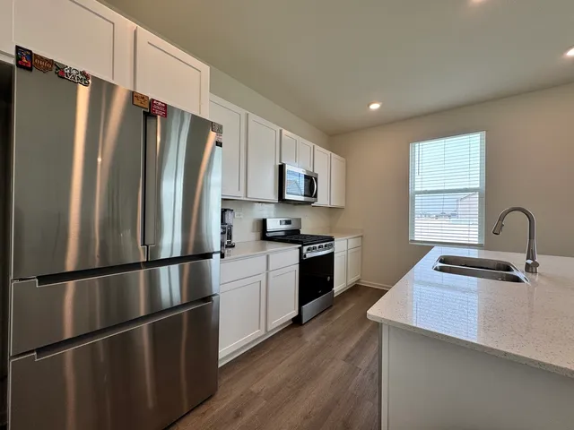 a kitchen with stainless steel appliances a refrigerator sink and cabinets