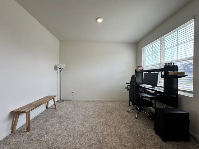 a view of a workspace with furniture and a window