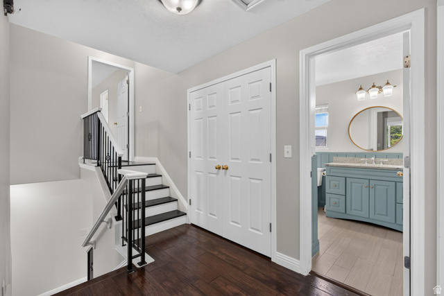2223 North Pointe Meadow Loop Lehi, UT 84048 - Photo 27 of 56 Hallway featuring wood-finish flooring, a contemporary staircase with black wrought iron balusters, and a built-in double-door closet
