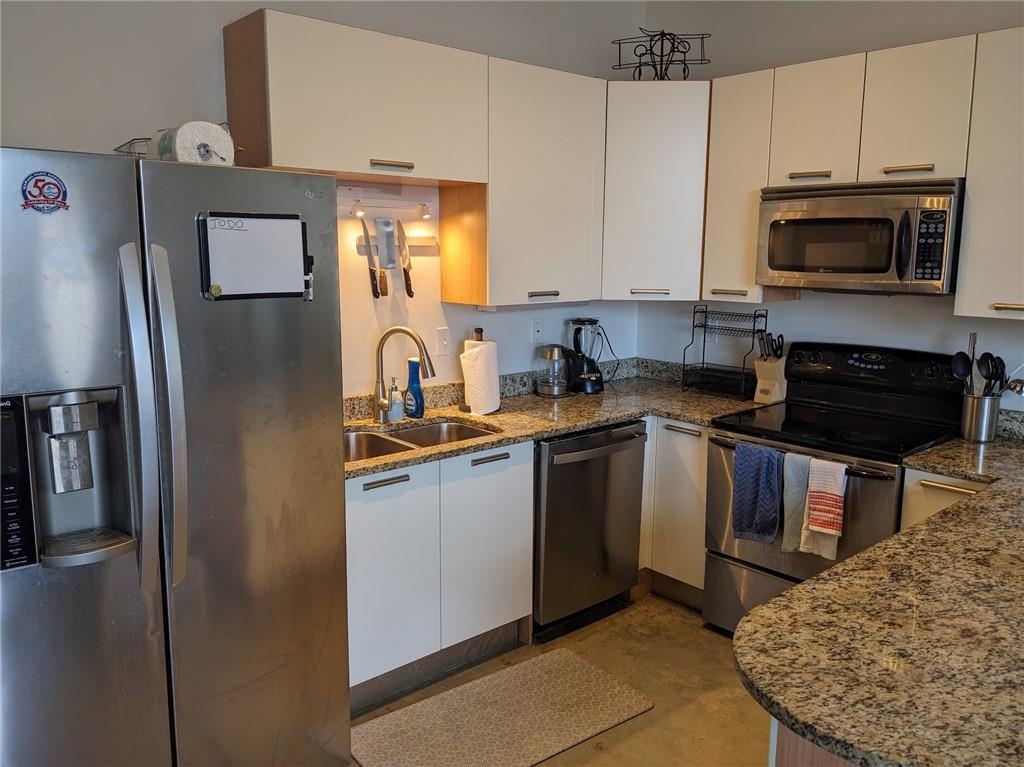 89 Mangum Street Southwest, Unit 207 Atlanta, GA 30313 - Photo 11 of 23 a kitchen with stainless steel appliances granite countertop a refrigerator a stove a sink and a microwave