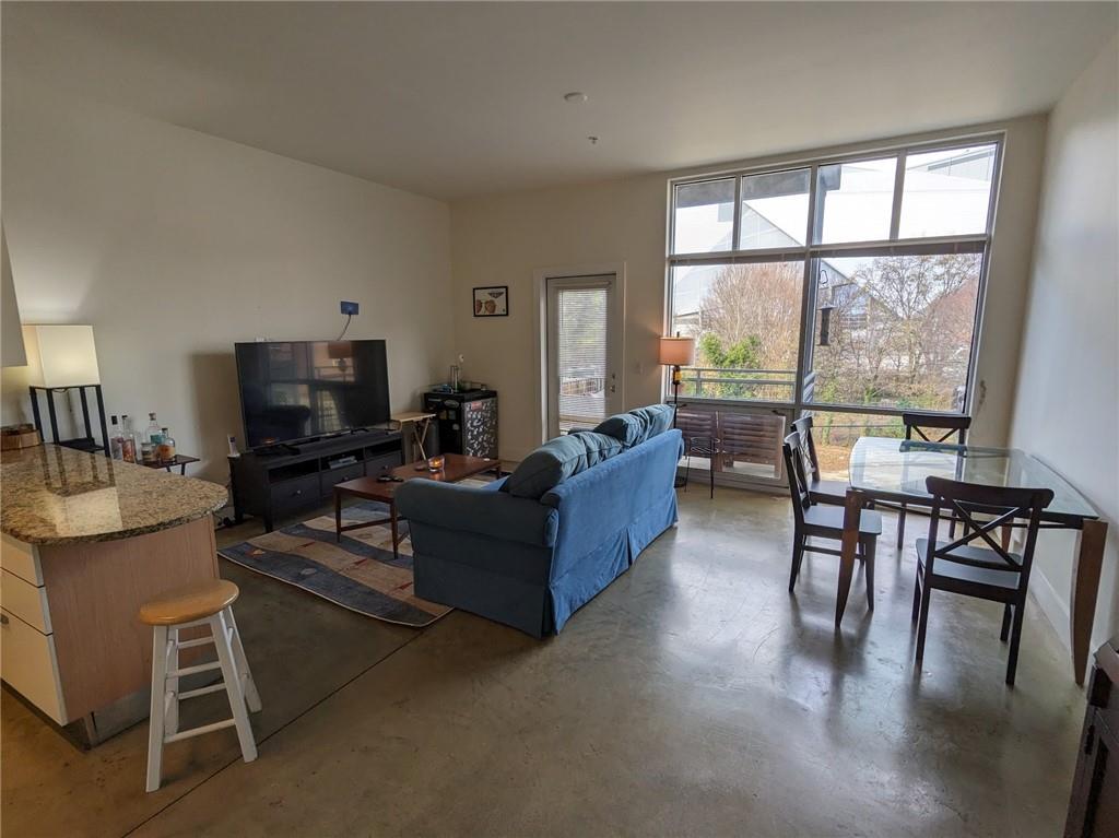 89 Mangum Street Southwest, Unit 207 Atlanta, GA 30313 - Photo 10 of 23 a living room with furniture a flat screen tv and a large window