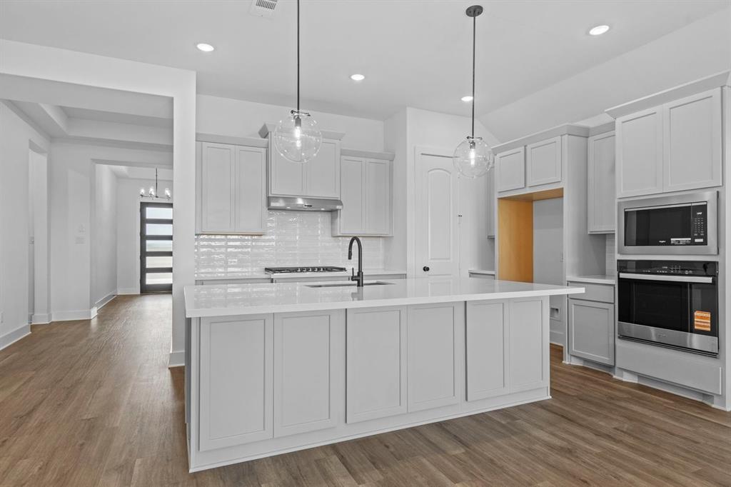 1792 Monarch Way Oak Point, TX 75068 - Photo 8 of 26 a large kitchen with cabinets wooden floor and a window
