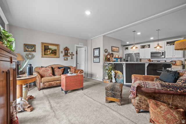 150 West 7500th South, Unit 13 Midvale, UT 84047 - Photo 13 of 32 Expansive open-concept living space with light gray wall tones and neutral carpeting