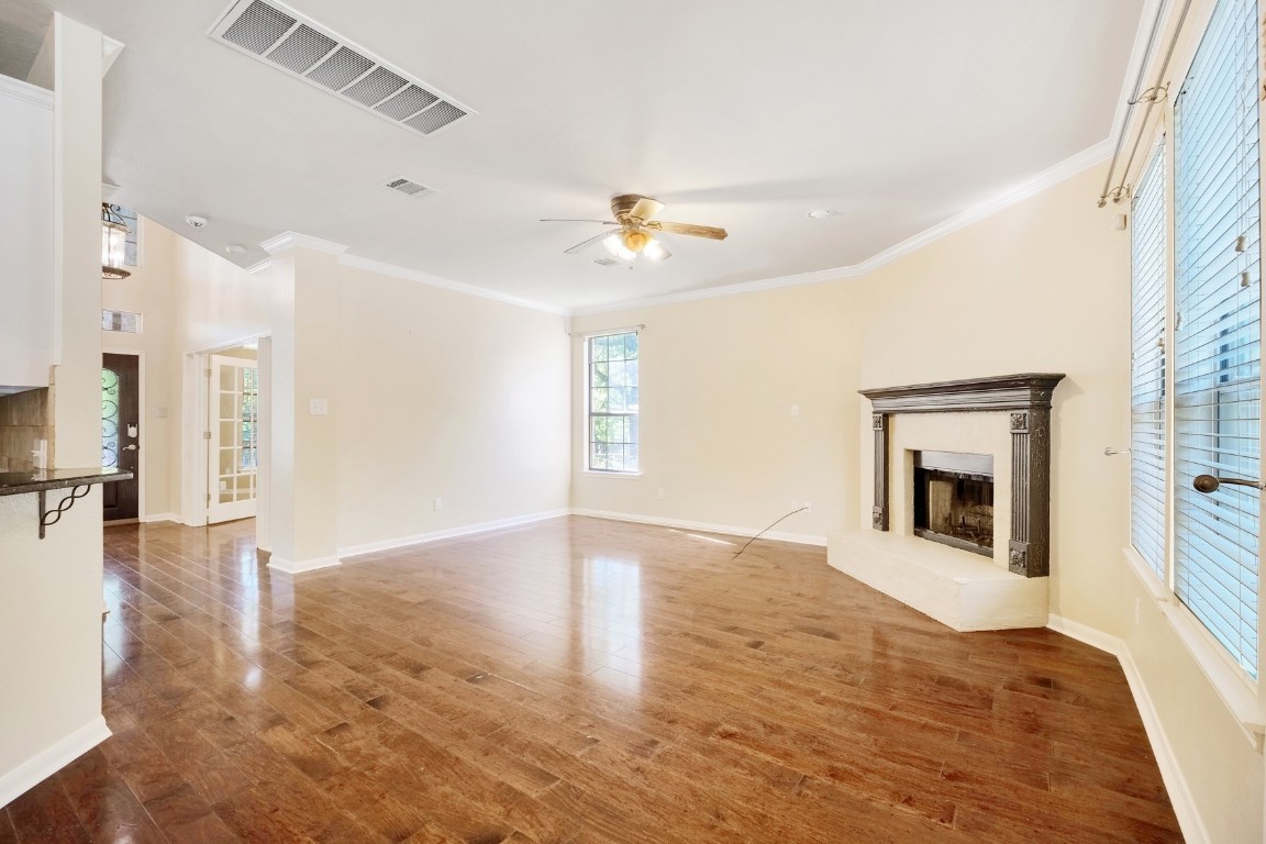 30103 Wingfoot Cove Georgetown, TX 78628 - Photo 11 of 38 an empty room with wooden floor fireplace and windows