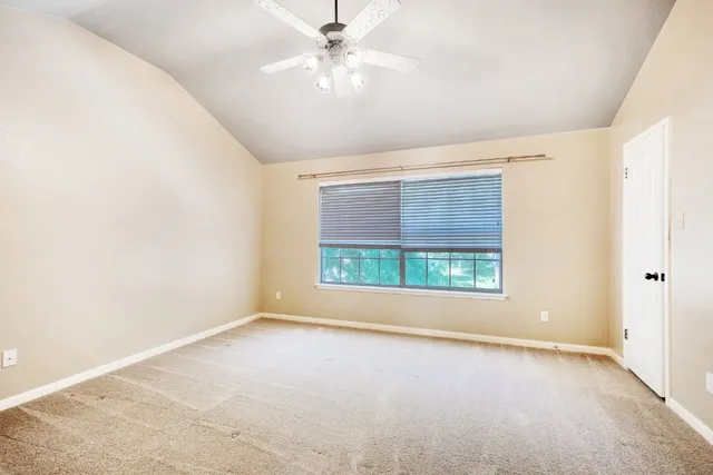 an empty room with a window and a fan