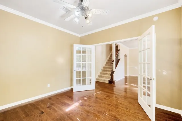 a view of an empty room with wooden floor and a window