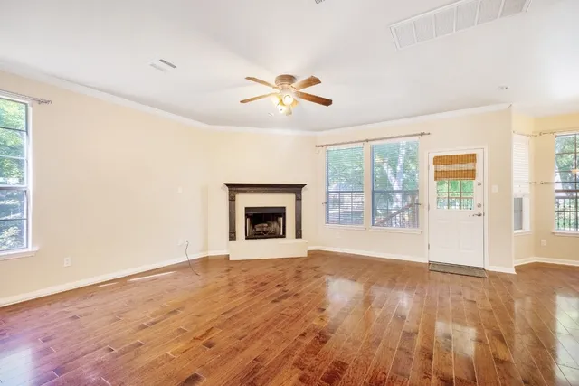 wooden floor fireplace and windows in an empty room