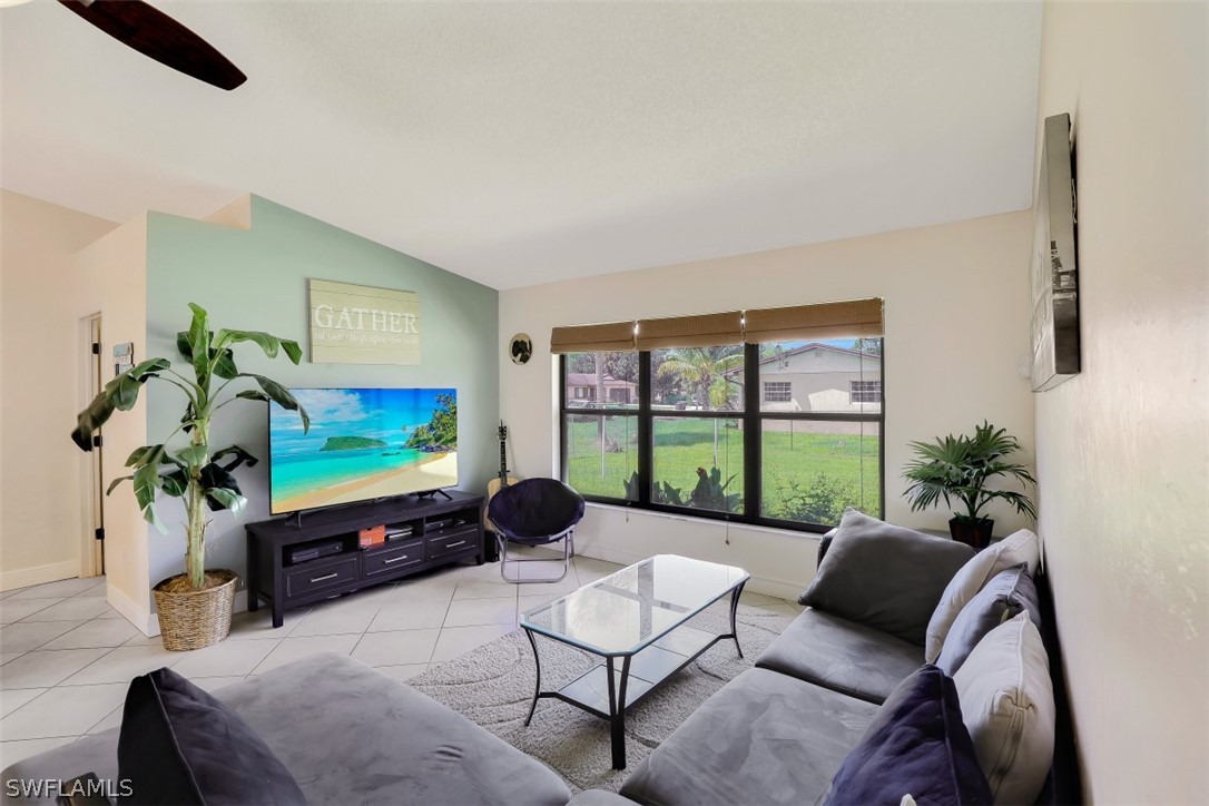 18507 Evergreen Road Fort Myers, FL 33967 - Photo 7 of 33 a living room with furniture floor to ceiling window and a flat screen tv
