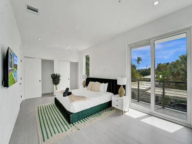 a living room with furniture a flat screen tv and a floor to ceiling window
