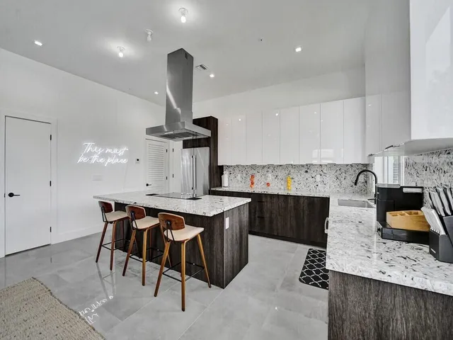 a kitchen with a stove a refrigerator and a dining table