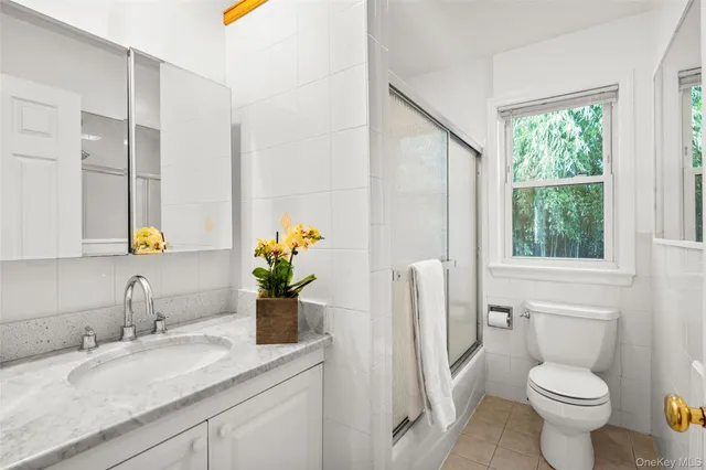 a bathroom with a granite countertop toilet sink and mirror