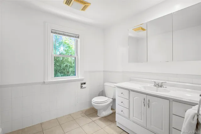 a spacious bathroom with a toilet sink and mirror