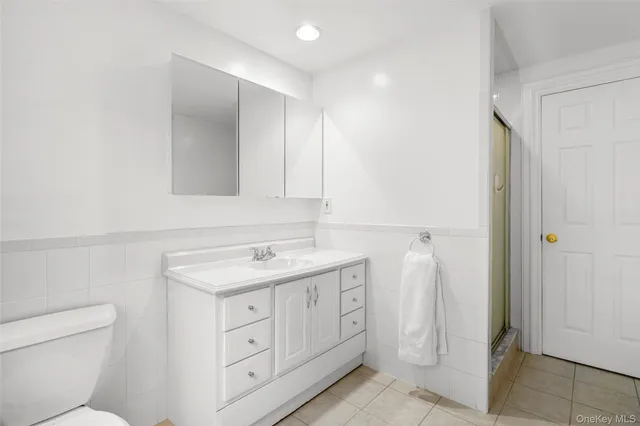 a spacious bathroom with a toilet sink and mirror
