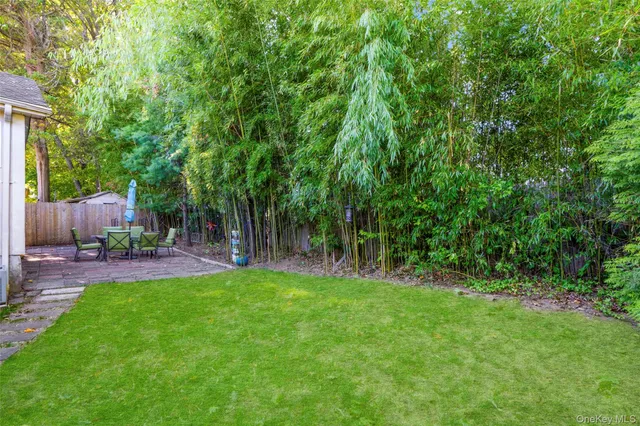 a view of a backyard with table and chairs and wooden fence