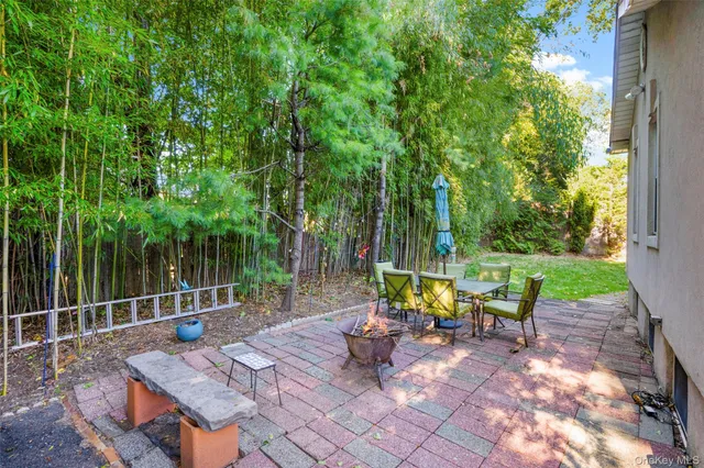 a view of a patio with table and chairs and wooden fence