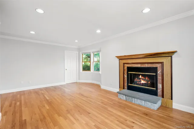 a view of an empty room with a fireplace and a window