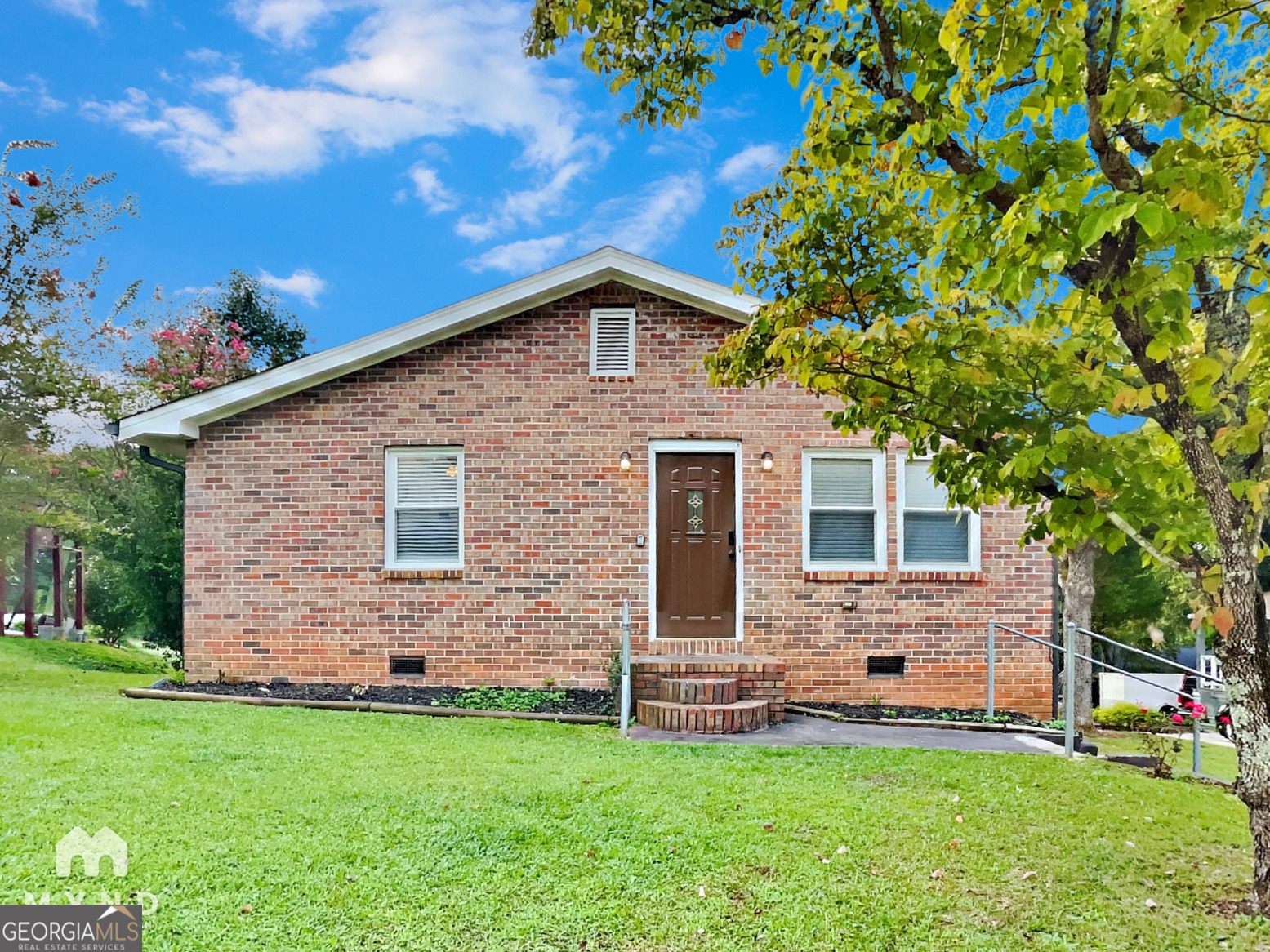 a front view of a house with a garden
