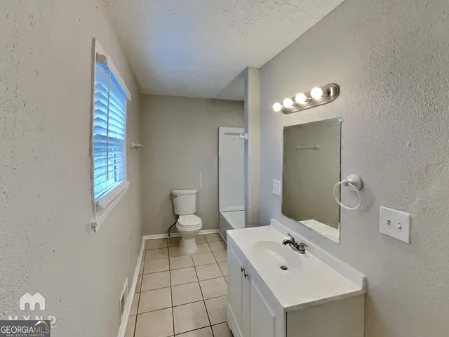 a bathroom with a sink toilet and mirror