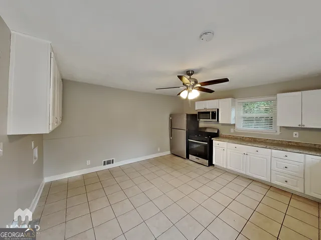 a kitchen with a stove cabinets and a refrigerator