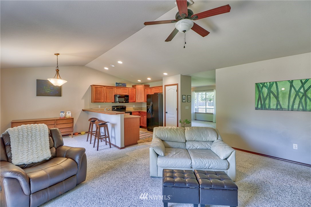 18047 Prairie Pointe Lane Southwest Rochester, WA 98579 - Photo 13 of 25 a living room with furniture kitchen view and a chandelier