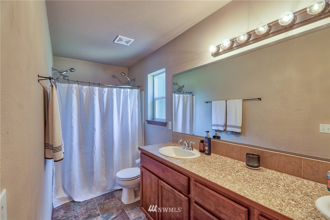 18047 Prairie Pointe Lane Southwest Rochester, WA 98579 - Photo 16 of 25 a bathroom with a granite countertop sink toilet and shower