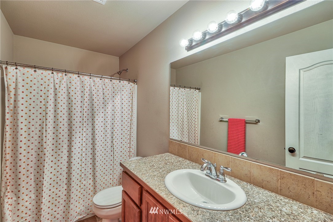 18047 Prairie Pointe Lane Southwest Rochester, WA 98579 - Photo 18 of 25 a bathroom with a granite countertop sink and a mirror