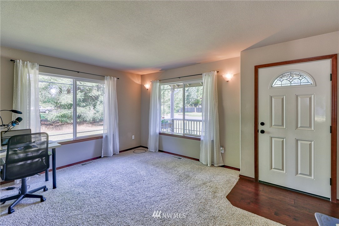 18047 Prairie Pointe Lane Southwest Rochester, WA 98579 - Photo 5 of 25 a view of an empty room with a window and wooden floor