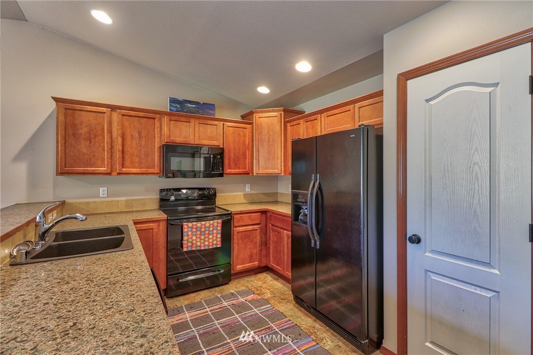 18047 Prairie Pointe Lane Southwest Rochester, WA 98579 - Photo 6 of 25 a kitchen with stainless steel appliances granite countertop a refrigerator stove and sink