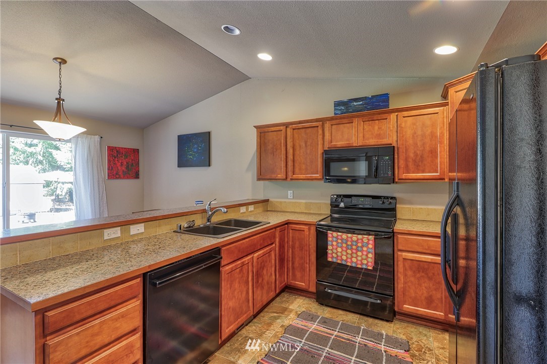 18047 Prairie Pointe Lane Southwest Rochester, WA 98579 - Photo 7 of 25 a kitchen with stainless steel appliances granite countertop a sink stove and refrigerator