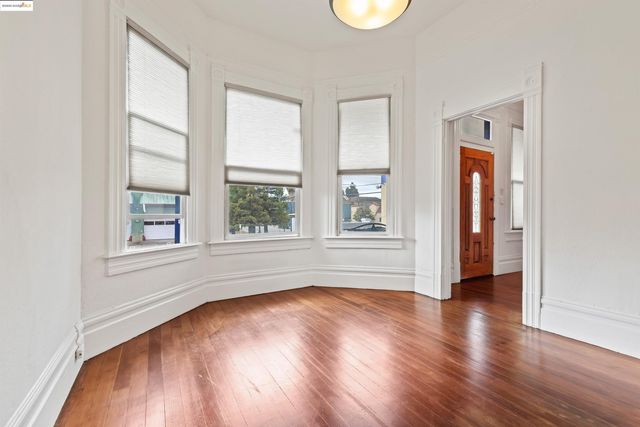a view of empty room with wooden floor and fireplace