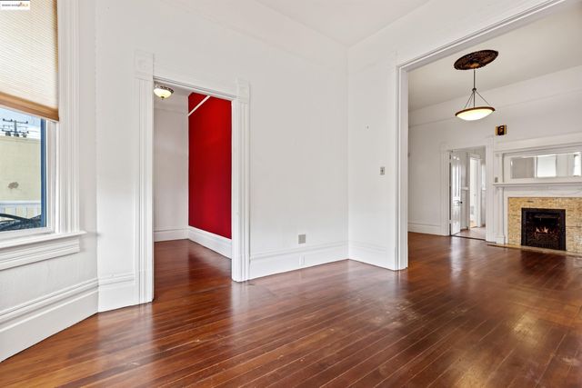 a view of a livingroom with wooden floor and a fireplace