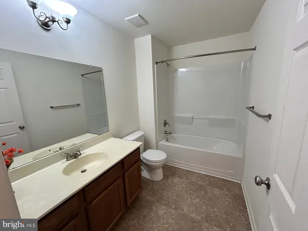 a bathroom with a double vanity sink toilet mirror and shower