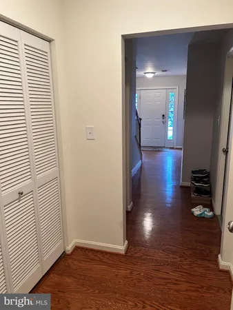 a view of a hallway with wooden floor and a living room