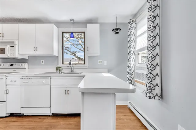 a kitchen with a sink dishwasher and a stove with wooden floor